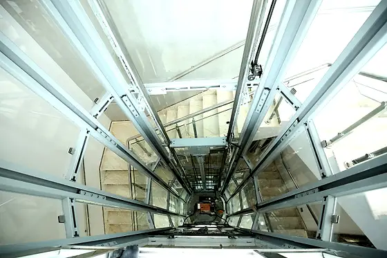 Glass lift and shaft seen from the stairs