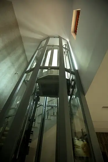 Glass lift and shaft seen from the stairs
