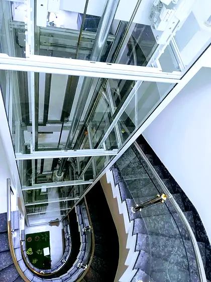 Glass lift and shaft seen from the stairs