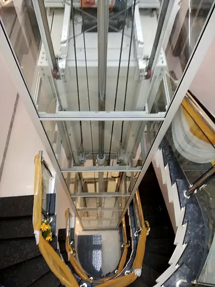 Glass lift and shaft seen from the stairs