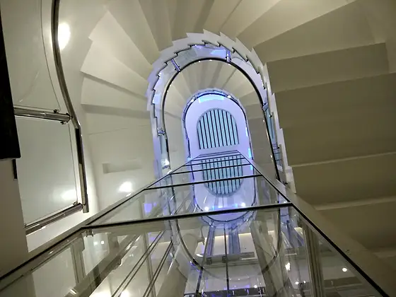 Glass lift and shaft seen from the stairs