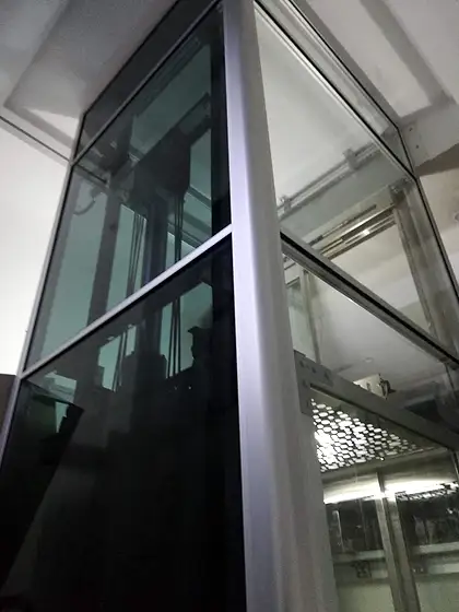 Glass lift and shaft seen from the stairs
