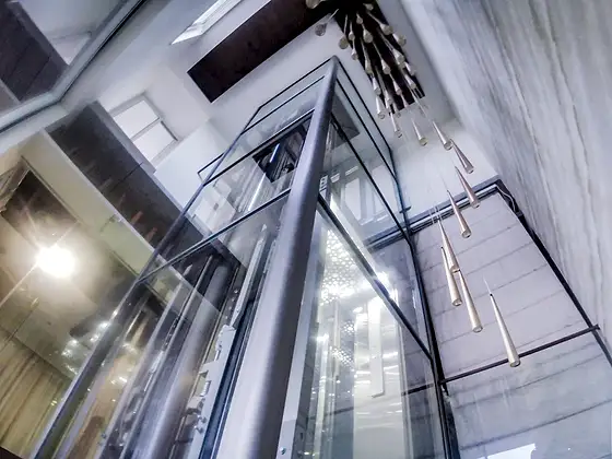 Glass lift and shaft seen from the stairs