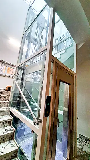 Glass lift and shaft seen from the stairs