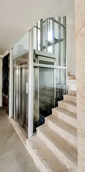 Glass lift and shaft seen from the stairs
