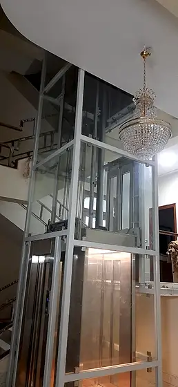 Glass lift and shaft seen from the stairs