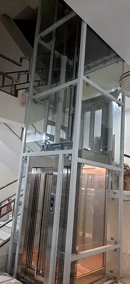 Glass lift and shaft seen from the stairs