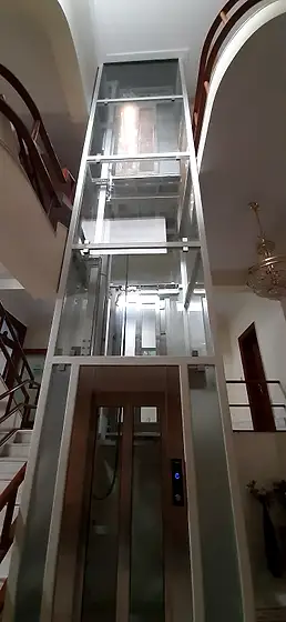 Glass lift and shaft seen from the stairs