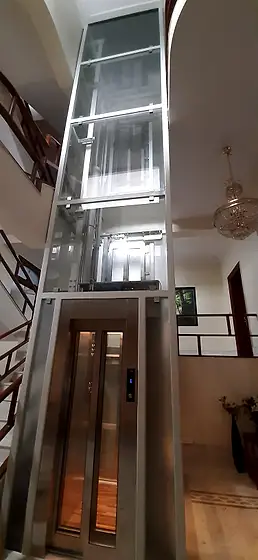 Glass lift and shaft seen from the stairs