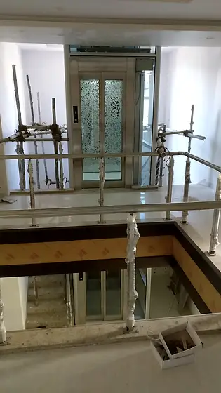 Glass lift and shaft seen from the stairs