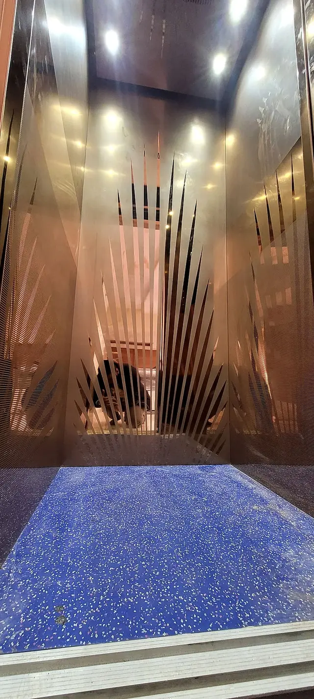 Designer lift cabin with etched copper panels and lighting