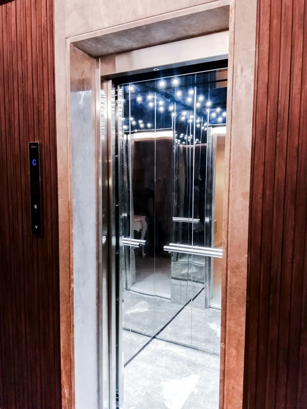 Designer lift cabin with a starry ceiling and wood-panel doors