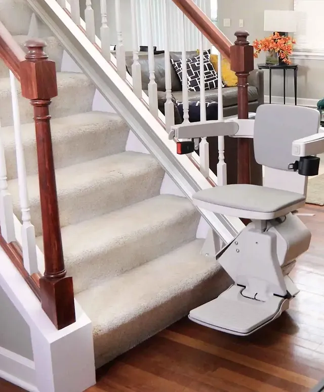 Straight stairlift beside a carpeted staircase