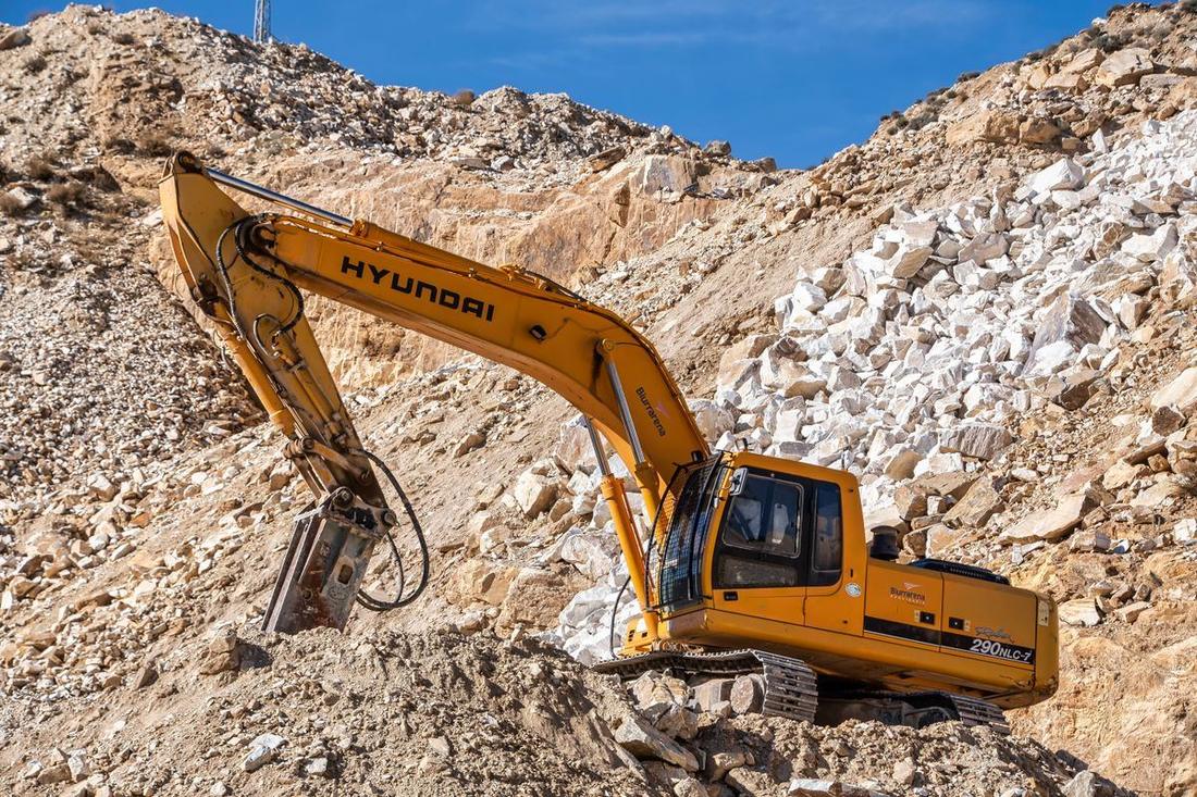Excavator working in a rocky quarry
