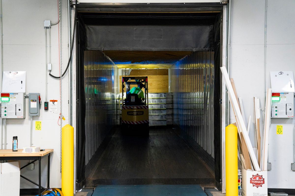 Forklift unloading goods at a warehouse loading dock